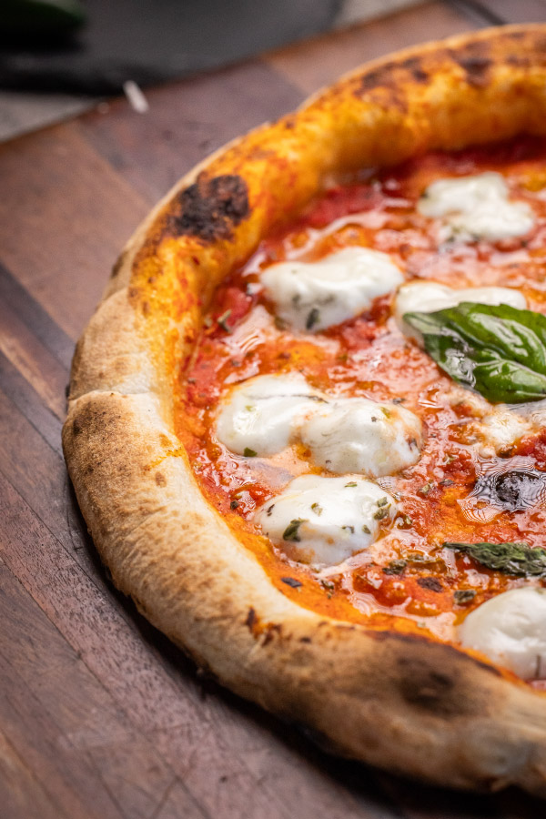 Pizza de búfala recién salida del horno de leña, con mozzarella de búfala y albahaca fresca